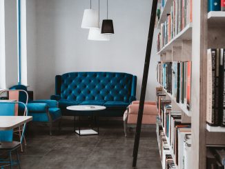 tufted blue 3-seat sofa near white wall and window